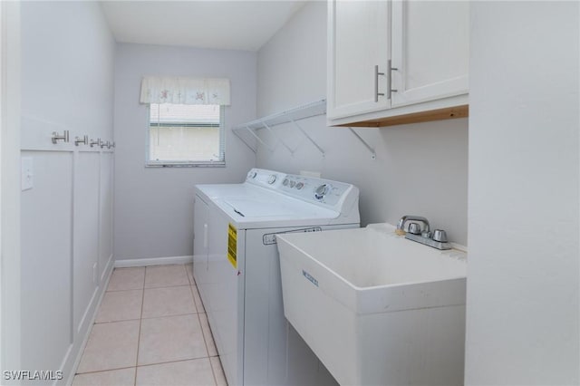 laundry room with separate washer and dryer, sink, light tile patterned floors, and cabinets