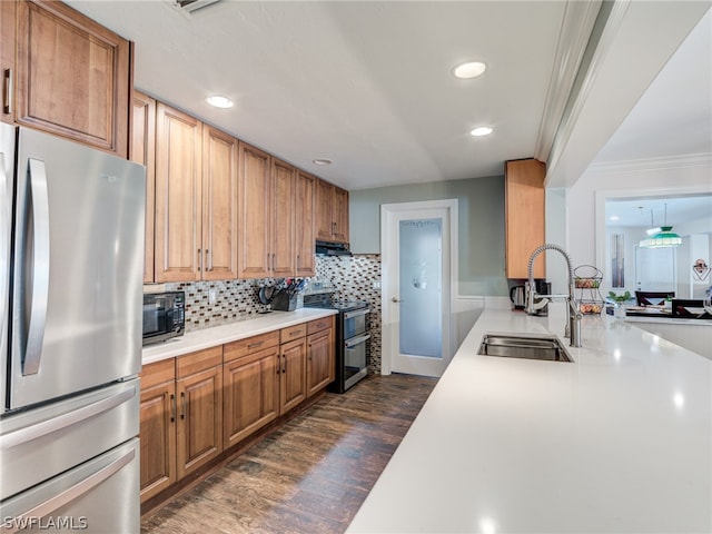 kitchen featuring stainless steel appliances, light countertops, a sink, and dark wood-style floors