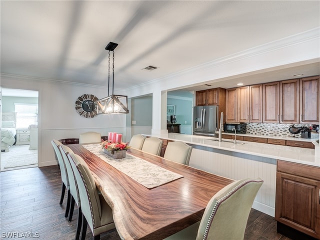 dining room featuring wainscoting, visible vents, dark wood-style flooring, and ornamental molding