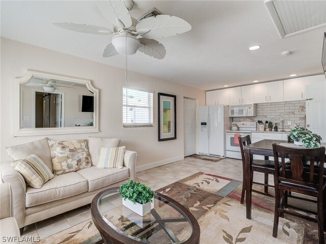 living room with a ceiling fan, recessed lighting, and baseboards