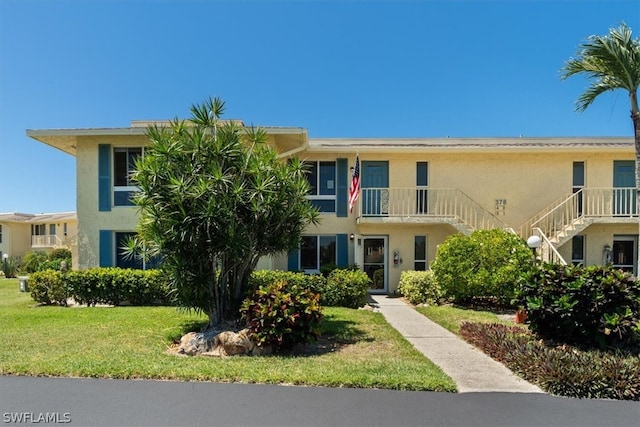 view of front of home featuring a front lawn and a balcony