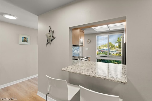 kitchen featuring light hardwood / wood-style floors and light stone countertops