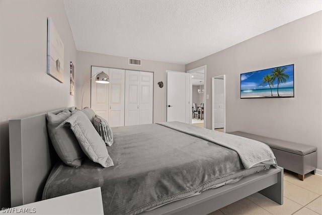 tiled bedroom featuring a closet and a textured ceiling