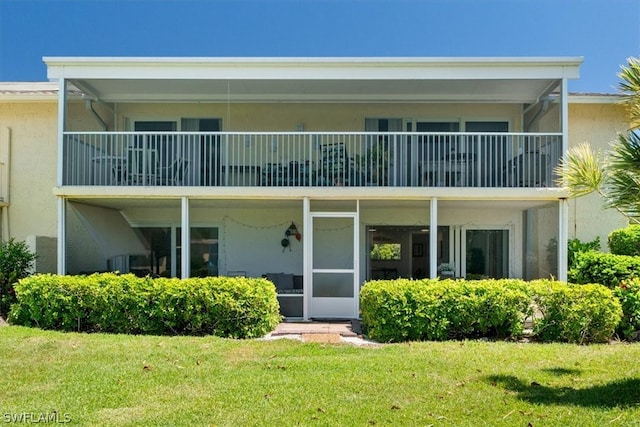 back of property featuring a yard and a balcony