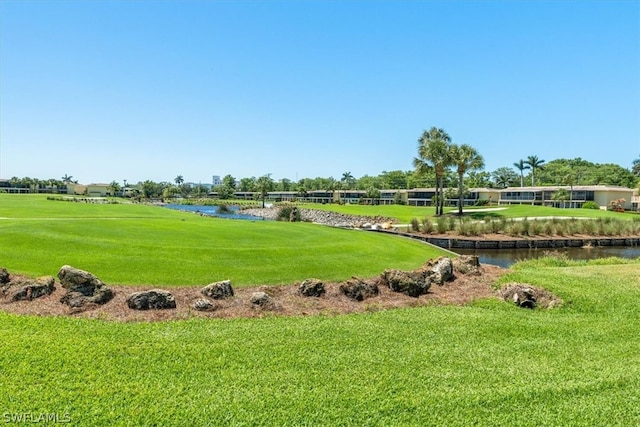 view of property's community featuring a lawn and a water view