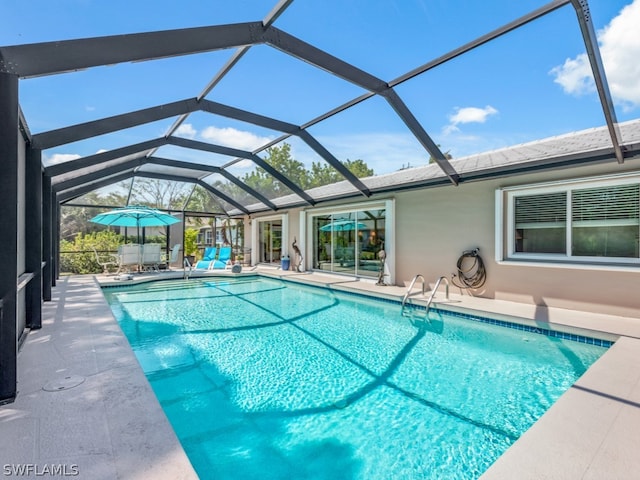 view of swimming pool featuring a patio and glass enclosure