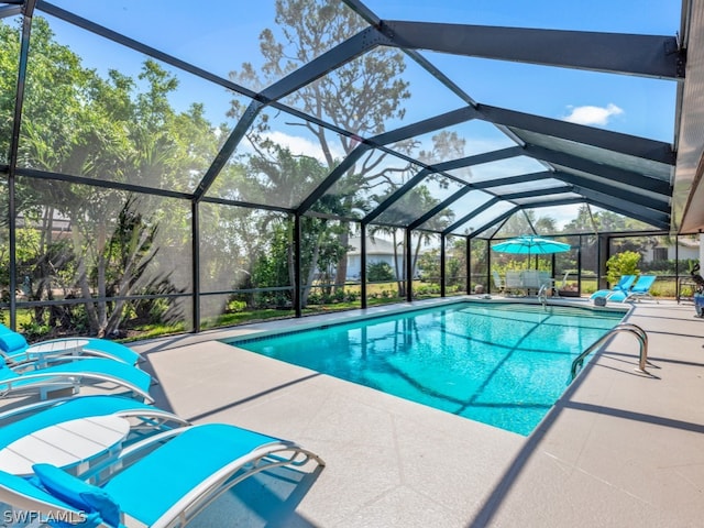 view of pool with a patio area and a lanai