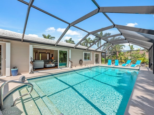 view of swimming pool featuring glass enclosure and a patio area