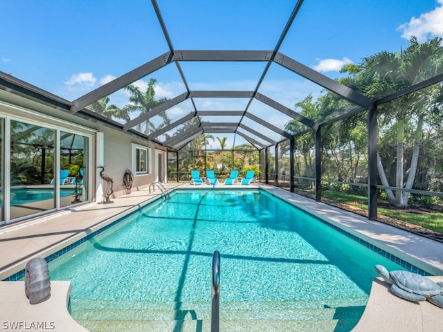 view of swimming pool featuring glass enclosure