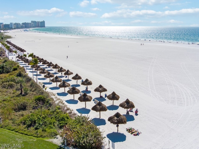 birds eye view of property featuring a beach view and a water view