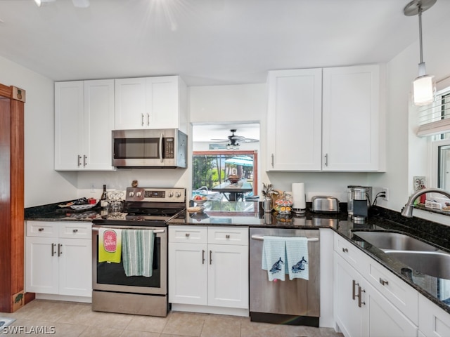 kitchen featuring hanging light fixtures, white cabinetry, appliances with stainless steel finishes, light tile floors, and ceiling fan