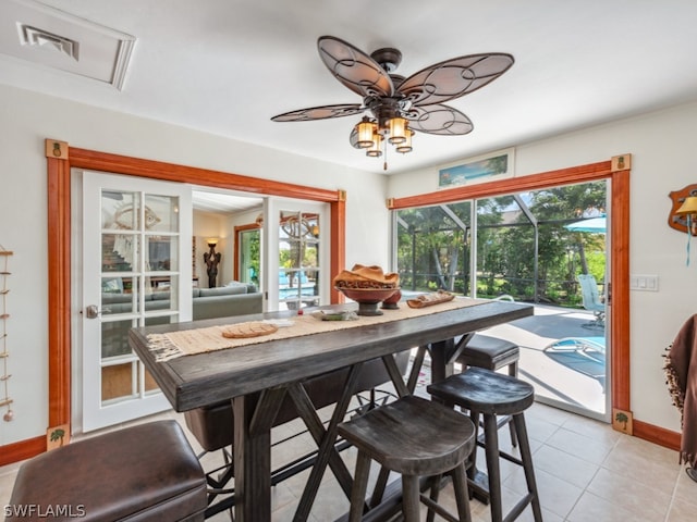 dining room with french doors, ceiling fan, a healthy amount of sunlight, and light tile floors