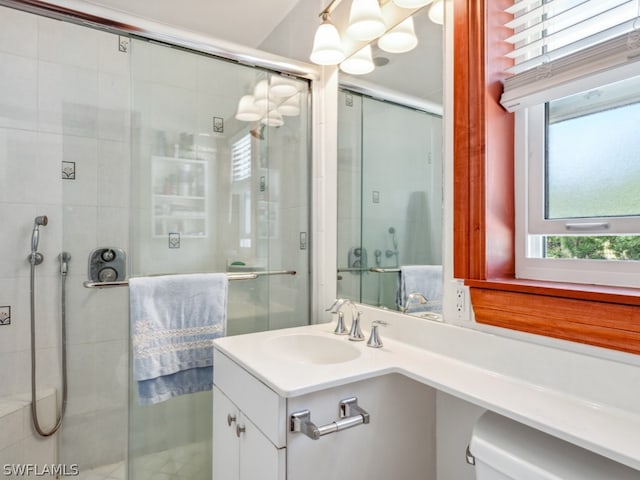 bathroom featuring vanity with extensive cabinet space, toilet, and walk in shower