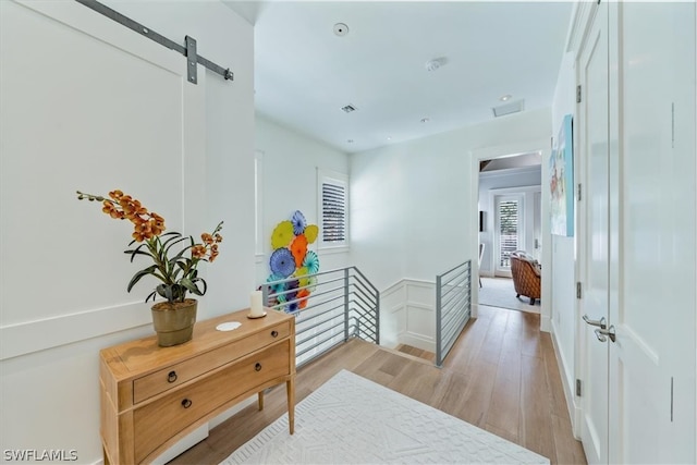 hallway featuring light hardwood / wood-style flooring and a barn door