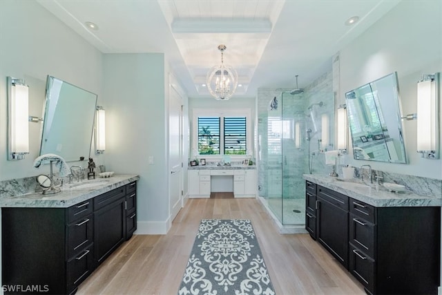 bathroom featuring a shower with door, a notable chandelier, hardwood / wood-style flooring, and dual vanity