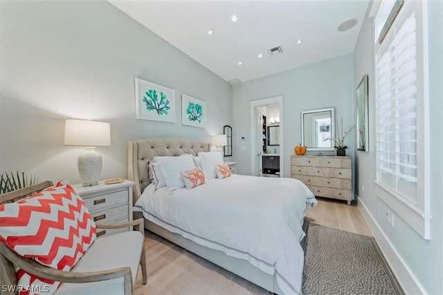 bedroom featuring light hardwood / wood-style flooring and connected bathroom