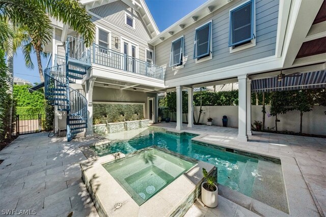 rear view of house featuring a patio area and a pool with hot tub