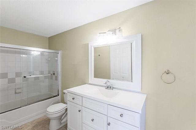 full bathroom featuring tile floors, combined bath / shower with glass door, vanity, and toilet