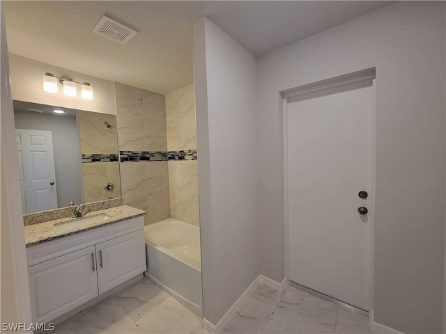 bathroom with vanity and tiled shower / bath