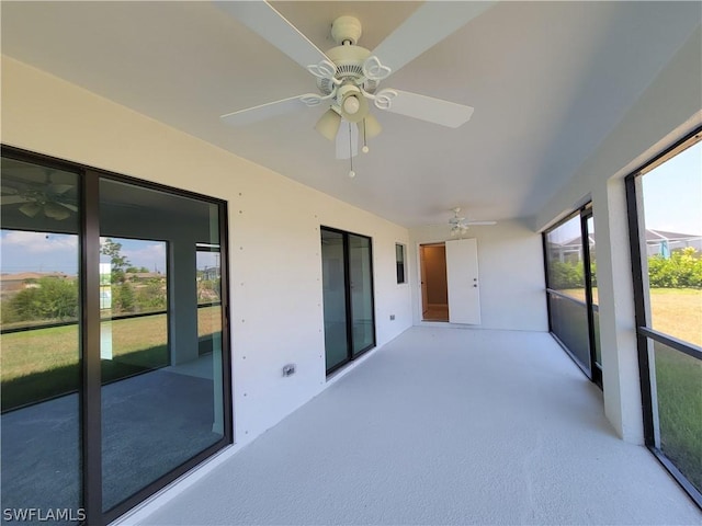 unfurnished sunroom with ceiling fan