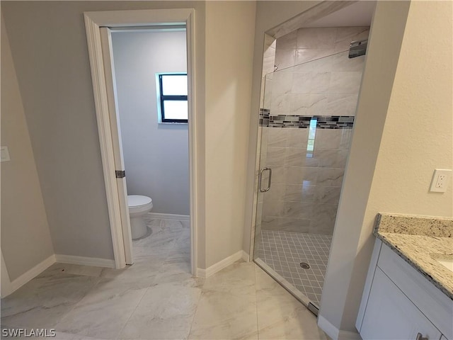 bathroom with an enclosed shower, vanity, and toilet