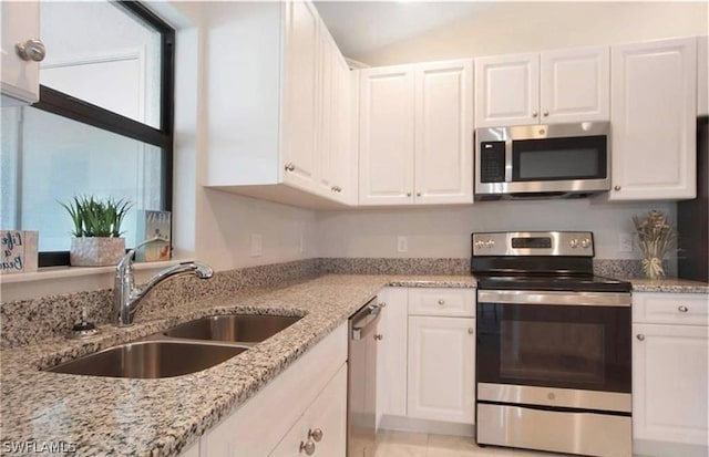 kitchen featuring light stone counters, white cabinetry, sink, and appliances with stainless steel finishes