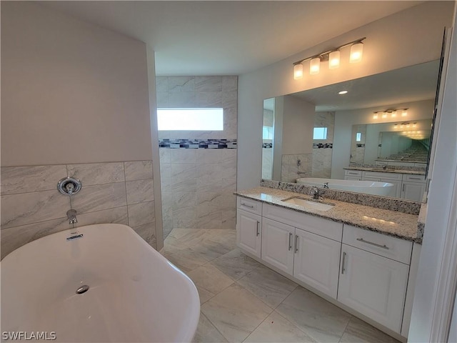 bathroom featuring vanity, tile walls, and a bathing tub