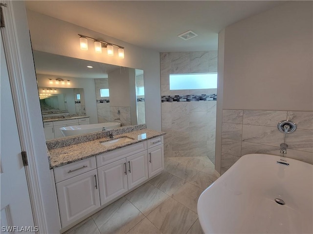 bathroom with plus walk in shower, vanity, and tile walls