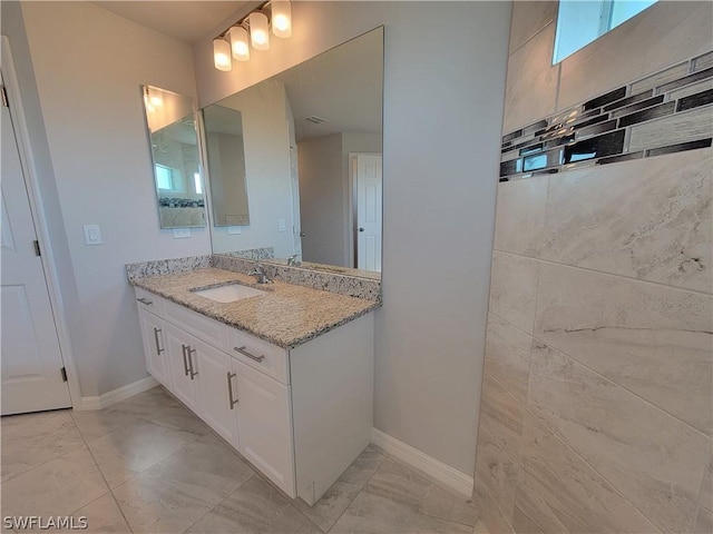 bathroom featuring vanity and backsplash