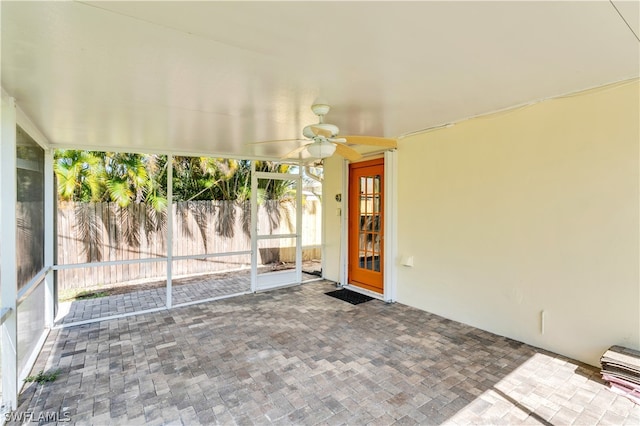 unfurnished sunroom featuring ceiling fan and a healthy amount of sunlight