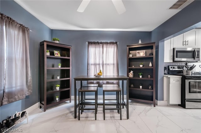 dining area featuring ceiling fan and light tile patterned flooring