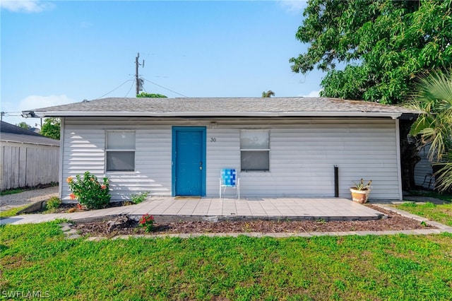 rear view of property featuring a lawn