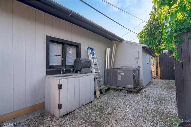 view of side of property with sink and central air condition unit