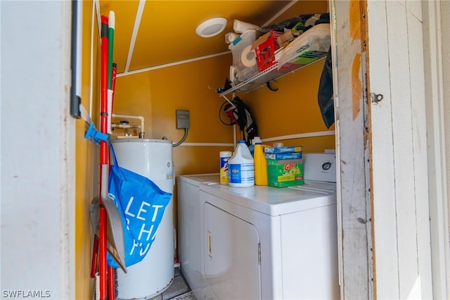 clothes washing area featuring gas water heater and separate washer and dryer