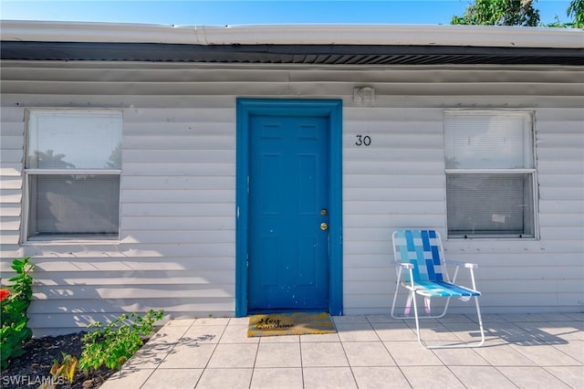 view of exterior entry with a patio area