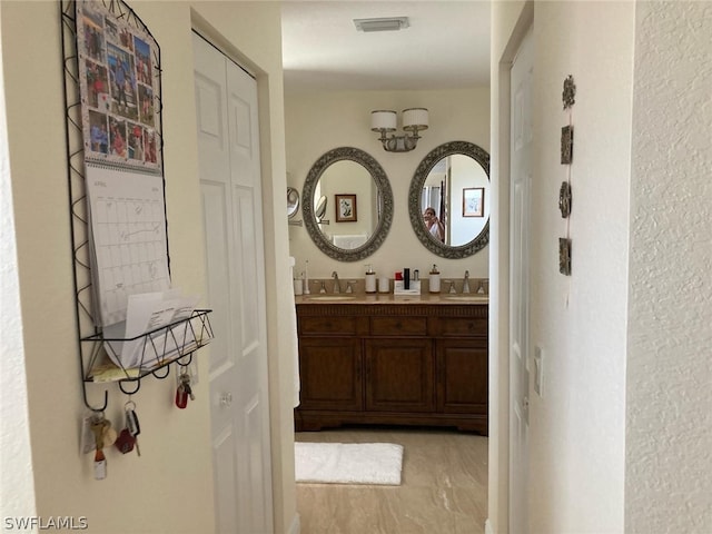 corridor with sink and light tile floors