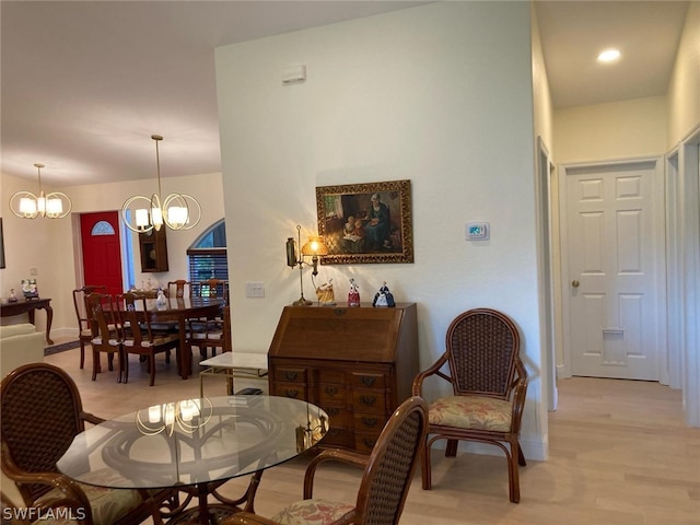 living area with an inviting chandelier and light hardwood / wood-style flooring