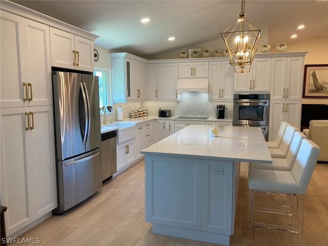 kitchen featuring a kitchen breakfast bar, backsplash, appliances with stainless steel finishes, custom range hood, and a kitchen island