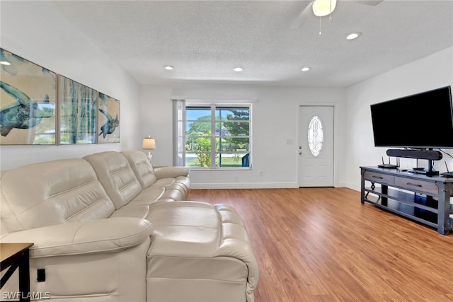 living room featuring a textured ceiling, ceiling fan, and hardwood / wood-style flooring