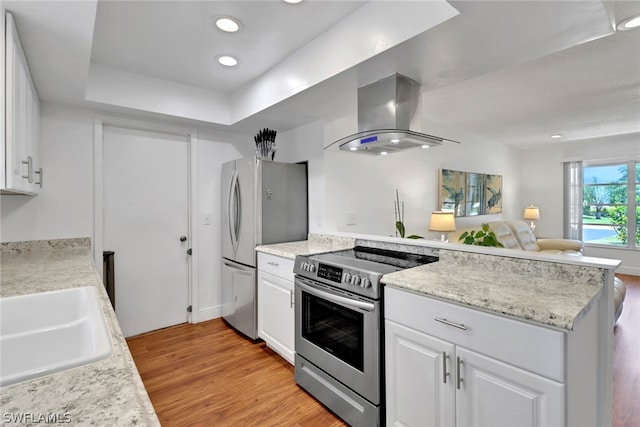 kitchen featuring sink, light hardwood / wood-style flooring, white cabinetry, stainless steel appliances, and range hood