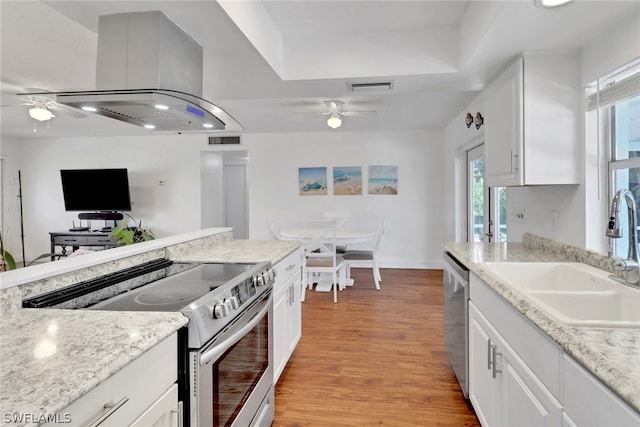 kitchen with light wood-type flooring, sink, white cabinets, appliances with stainless steel finishes, and ceiling fan