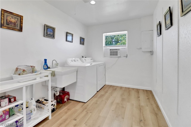 clothes washing area with separate washer and dryer, light hardwood / wood-style floors, electric panel, and cooling unit