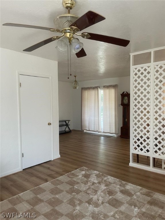 unfurnished room with ceiling fan and dark wood-type flooring