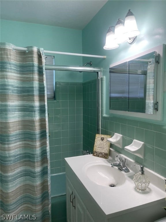 bathroom featuring tile walls, tasteful backsplash, vanity, and tiled shower / bath combo