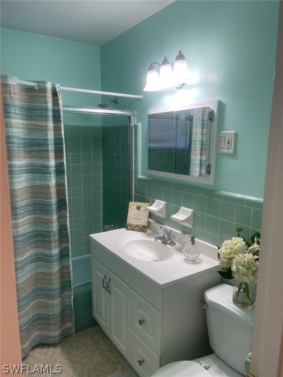 full bathroom with tiled shower / bath, vanity, tile walls, backsplash, and toilet