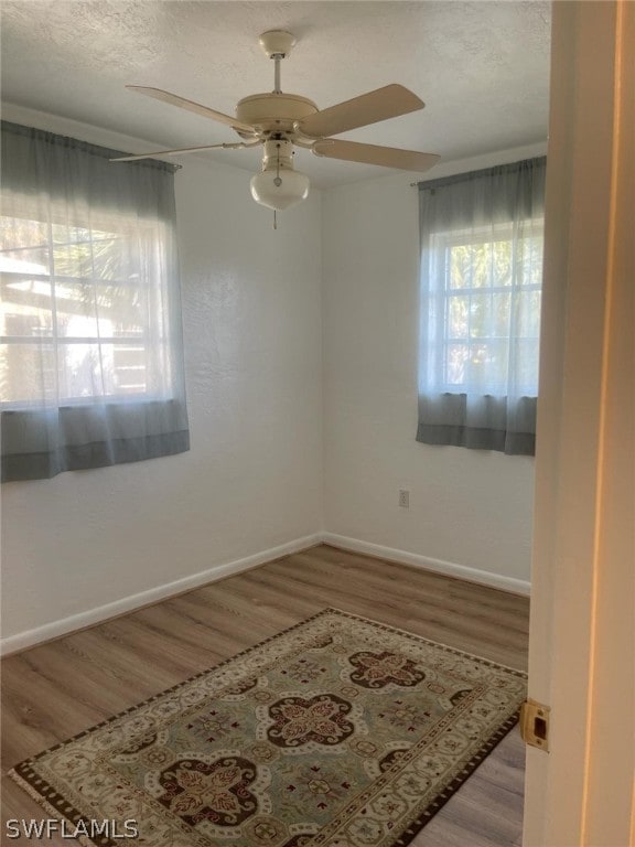 empty room with ceiling fan and hardwood / wood-style floors