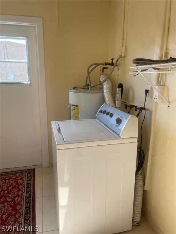 clothes washing area with light tile flooring, washer / dryer, and gas water heater