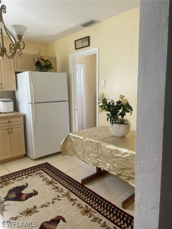 kitchen featuring white refrigerator and light tile floors