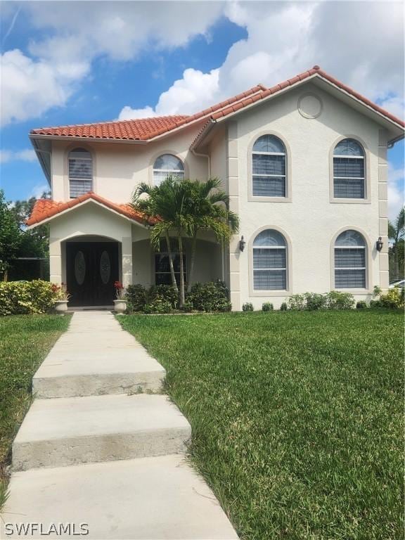 mediterranean / spanish-style house with a front lawn