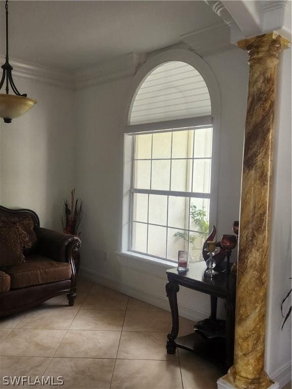 interior space featuring light tile patterned flooring, ornamental molding, and decorative columns